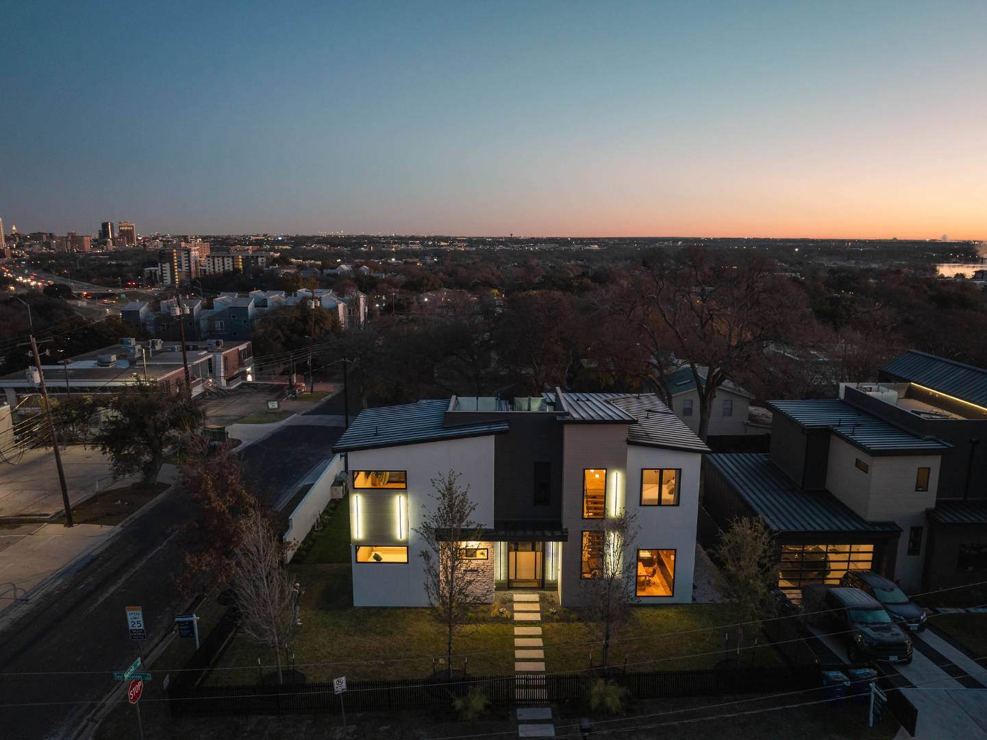 Luxury home illuminated at dusk with panoramic city views. Austin, TX | CKN Homes