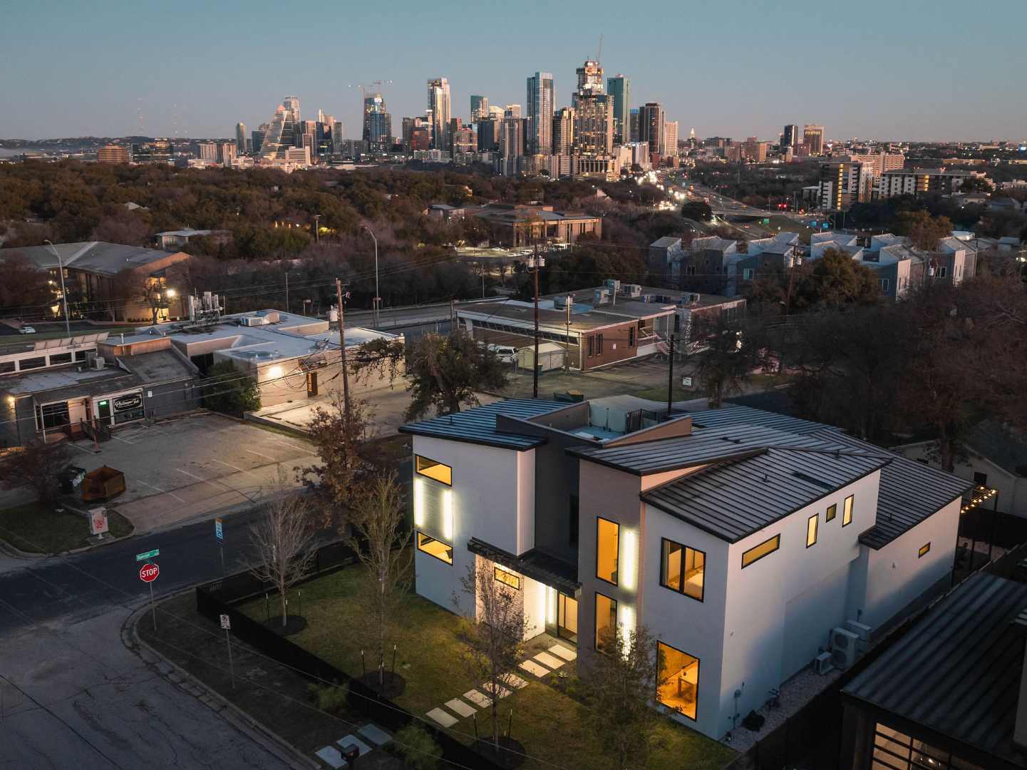 Modern home with Austin skyline and glowing evening lights. Austin, TX | CKN Homes