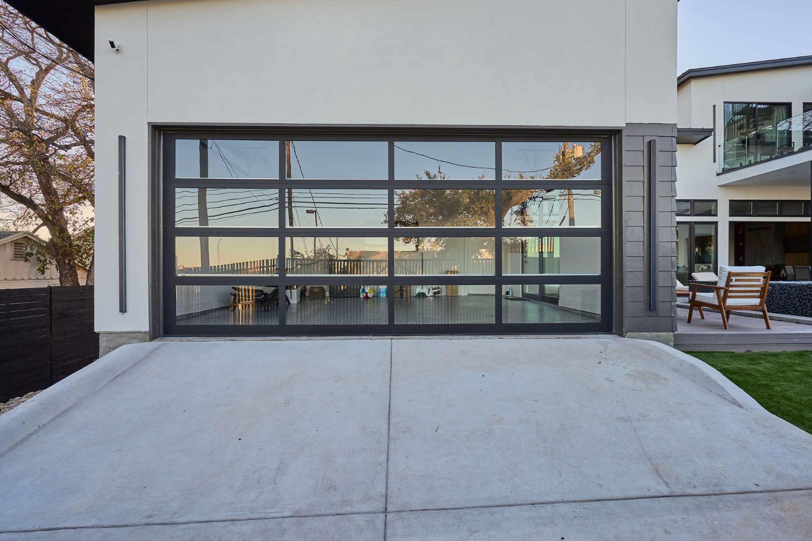 Expansive glass garage door reflecting outdoor scenery. Austin, TX | CKN Homes