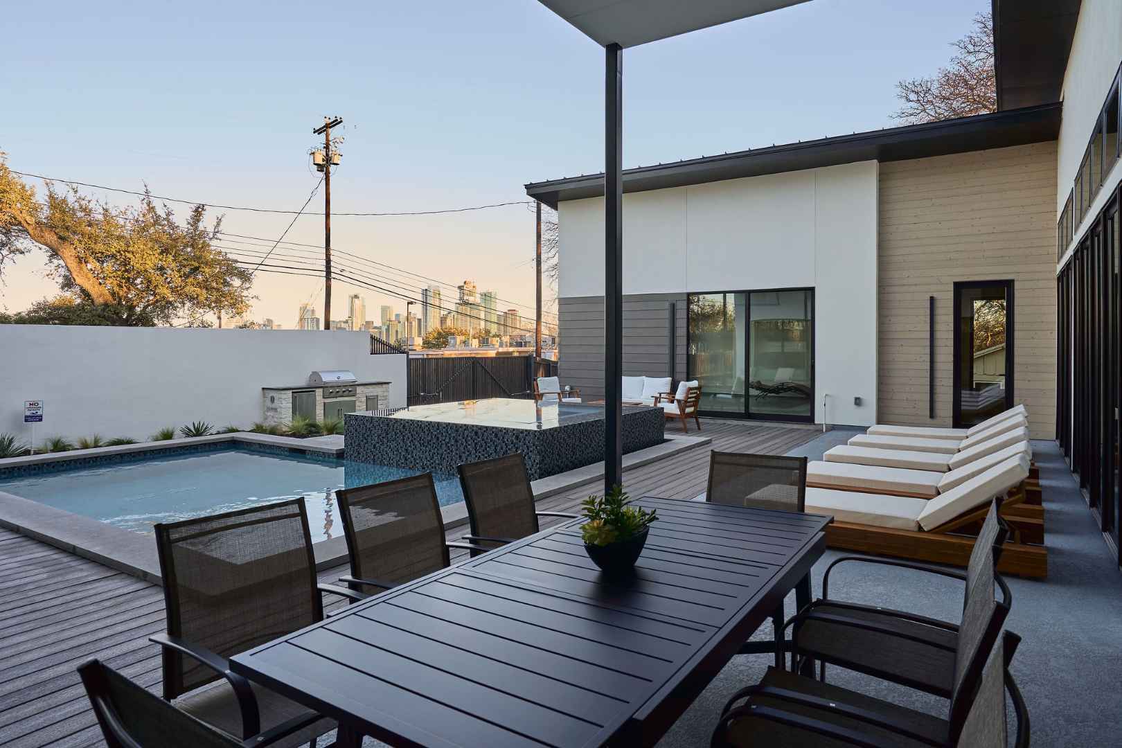 Elegant outdoor dining with a pool and city views. Austin, TX | CKN Homes