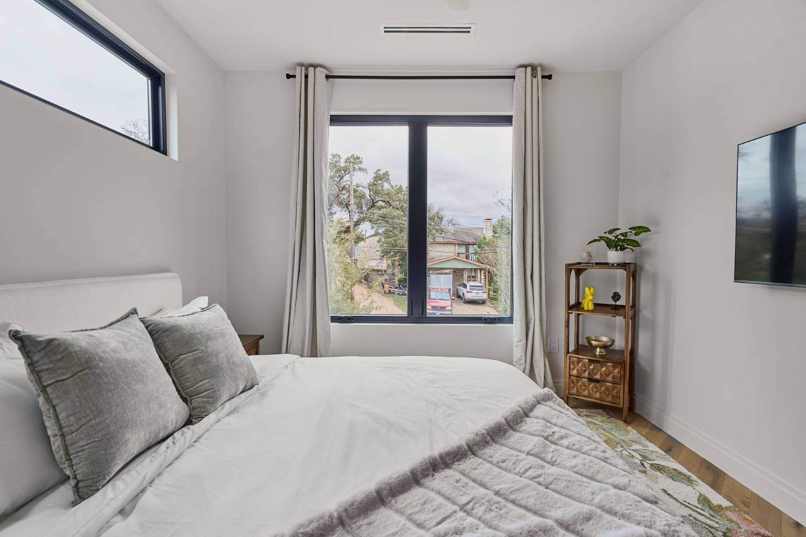 Cozy bedroom with neutral tones and outdoor view. Austin, TX | CKN Homes