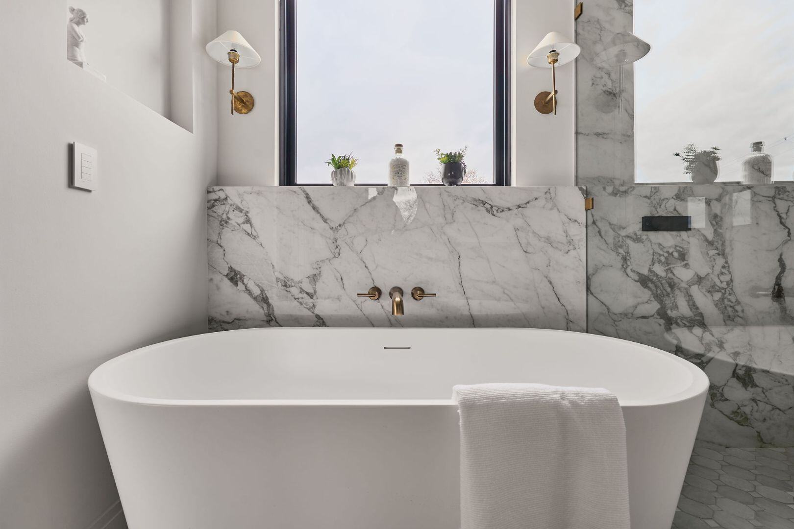 Marble bathroom with freestanding tub and gold fixtures. Austin, TX | CKN Homes